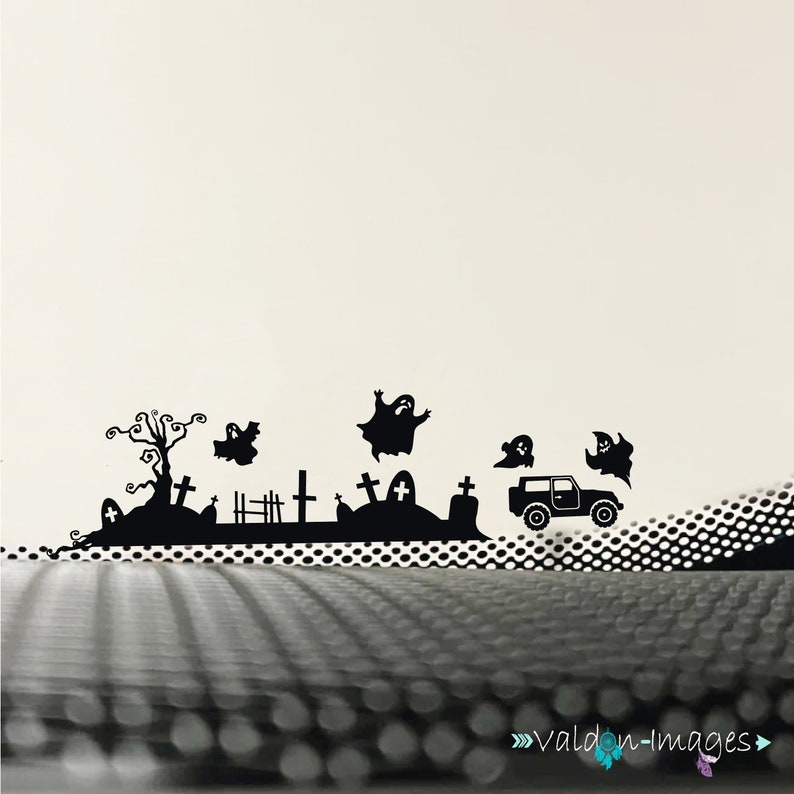 May include: Black and white silhouette wall decal featuring a spooky Halloween graveyard scene with a car, ghosts, and a tree.