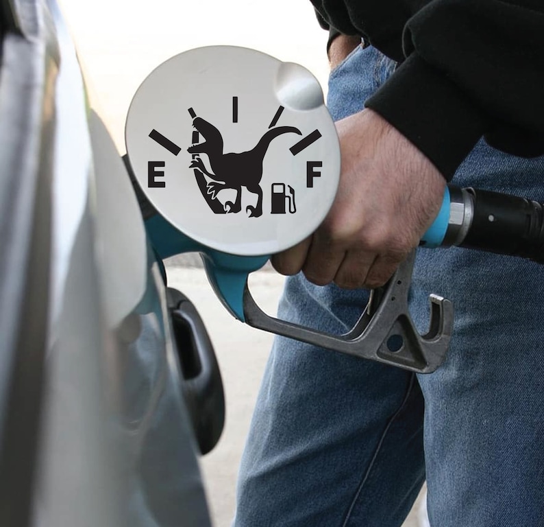 May include: A blue gas pump nozzle with a black dinosaur silhouette on the fuel gauge. The gauge reads "E" for empty and "F" for full.