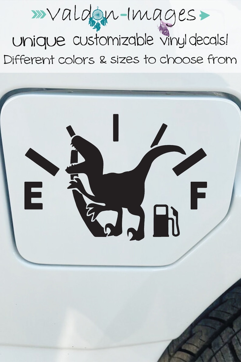 May include: A black and white vinyl decal of a dinosaur with a gas pump in its mouth. The dinosaur is positioned on a gas gauge with the letters "E" and "F" on either side. The decal is designed to be placed on a car's gas tank.