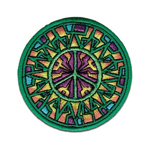 May include: A round, green embroidered patch with a peace sign in the center. The peace sign is surrounded by a colorful, geometric design with shades of orange, yellow, purple, and blue.