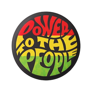 Może przedstawiać: Czarno-biały guzik z czerwonym, żółtym i zielonym wzorem koła. Tekst "POWER TO THE PEOPLE" jest napisany stylizowanym fontem.