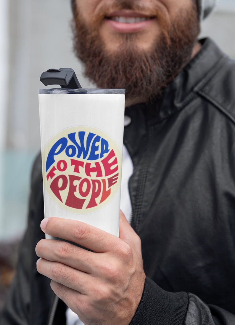 May include: White stainless steel tumbler with a black lid and a red, white, and blue circular sticker that says "Power to the People".
