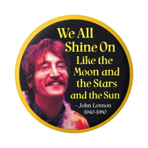 May include: A yellow button with a black background featuring a photo of John Lennon and a quote: "We All Shine On Like the Moon and the Stars and the Sun - John Lennon 1940-1980".