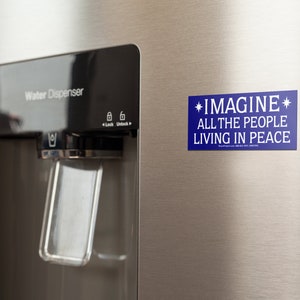 May include: A blue refrigerator magnet with white text that reads "*IMAGINE* ALL THE PEOPLE LIVING IN PEACE".