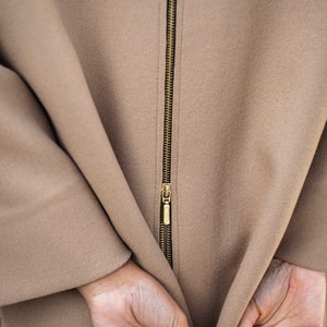 Camel color wool blazer with a zipper in the back. The functional zipper enlarge the width of the back, making it more spacious.
