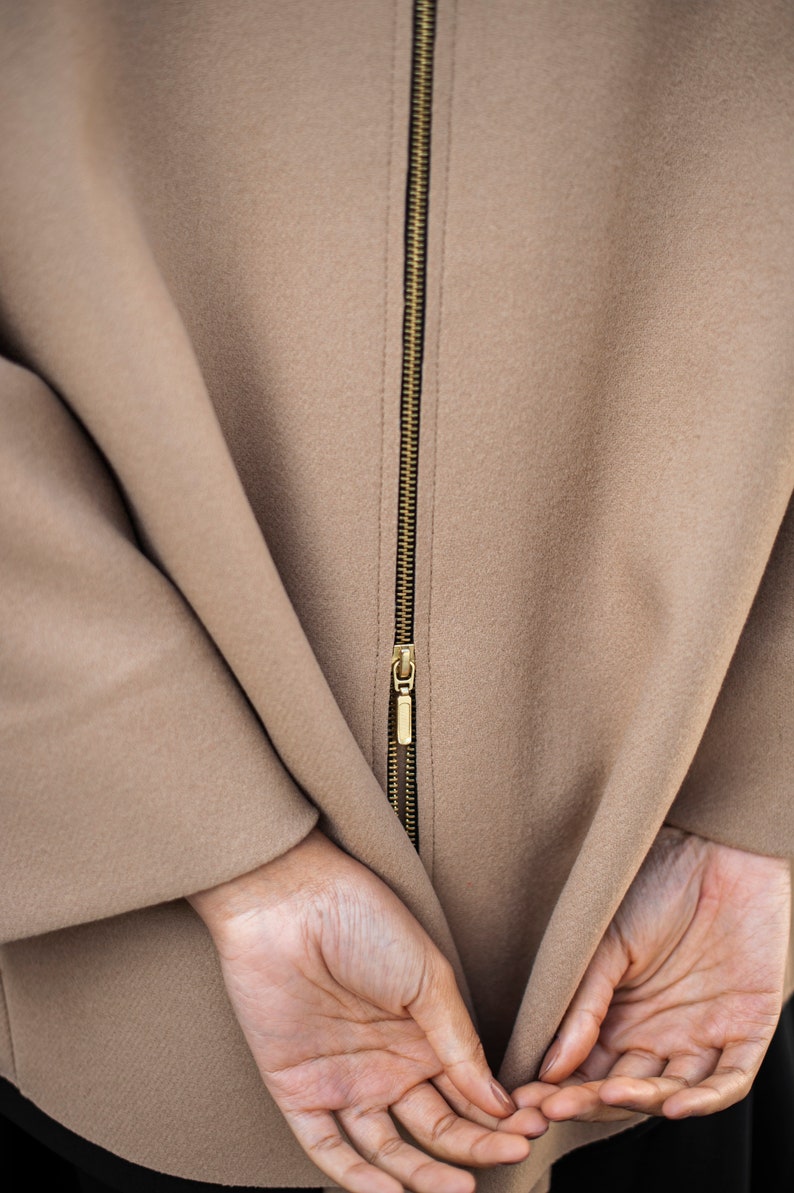 Camel color wool blazer with a zipper in the back. The functional zipper enlarge the width of the back, making it more spacious.