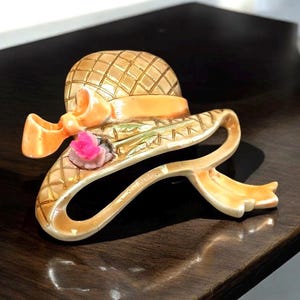 Charming vintage brooch shaped like a ribboned straw hat or bonnet