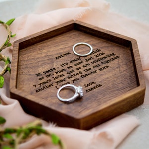 May include: A hexagonal dark wood ring dish featuring engraved text that reads: Andrew, 28 years - it's crazy to think we met when we were just kids. 7 years later and we are celebrating another year around the sun together. I love you forever more. Love, Amanda.