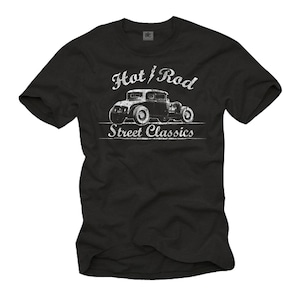 Könnte beinhalten: Schwarzes T-Shirt mit einem weißen Aufdruck eines klassischen Hot-Rod-Autos. Der Text über dem Auto lautet "Hot / Rod", und darunter "Street Classics", alles in einer verwitterten weißen Schrift. Die Autoillustration ist ebenfalls weiß.