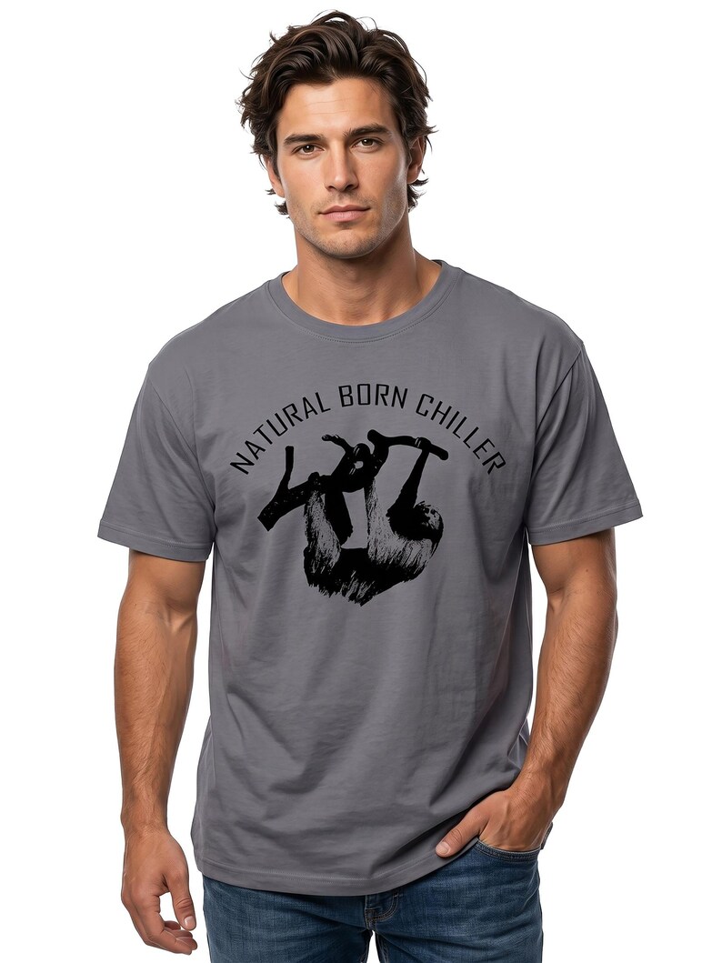 Pu&ograve; includere: T-shirt grigia con grafica nera di un bradipo appeso a un ramo. Il testo "NATURAL BORN CHILLER" &egrave; sopra il bradipo. La maglietta ha maniche corte e girocollo.