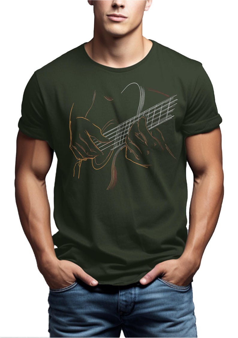 May include: Dark green t-shirt featuring a line art illustration of hands playing a guitar. The guitar strings and fretboard are visible, with the hands in a playing position. The design is in shades of orange and white.