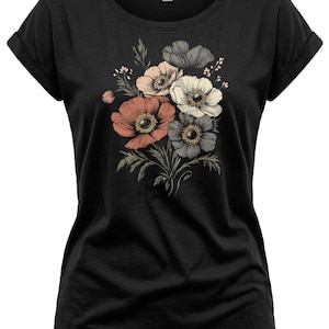 May include: Black t-shirt featuring a floral design. The graphic includes a bouquet of anemone flowers in shades of coral, peach, white, and gray, with green leaves. The shirt has a crew neck and rolled sleeves.