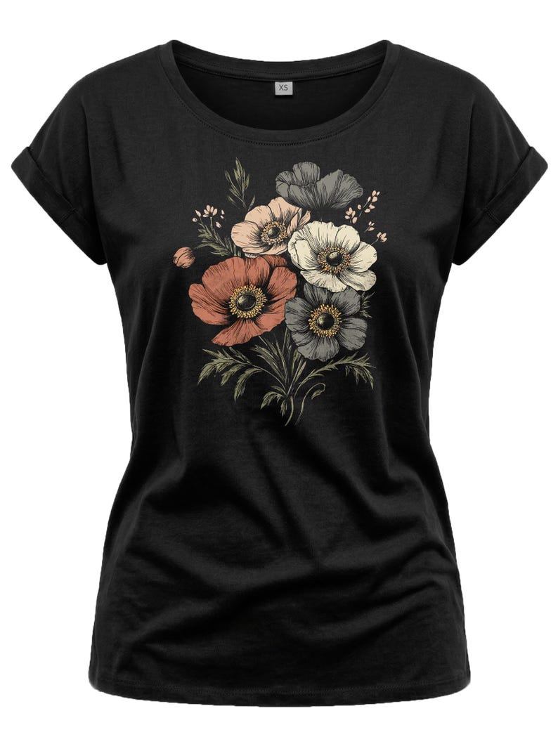 May include: Black t-shirt featuring a floral design. The graphic includes a bouquet of anemone flowers in shades of coral, peach, white, and gray, with green leaves. The shirt has a crew neck and rolled sleeves.