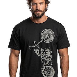 以下が含まれることがあります： 黒いTシャツ。バイクの詳細なシルバーグラフィックが特徴です。デザインには、バイクのホイール、エンジン、フレームが含まれています。Tシャツは半袖で、クルーネックです。