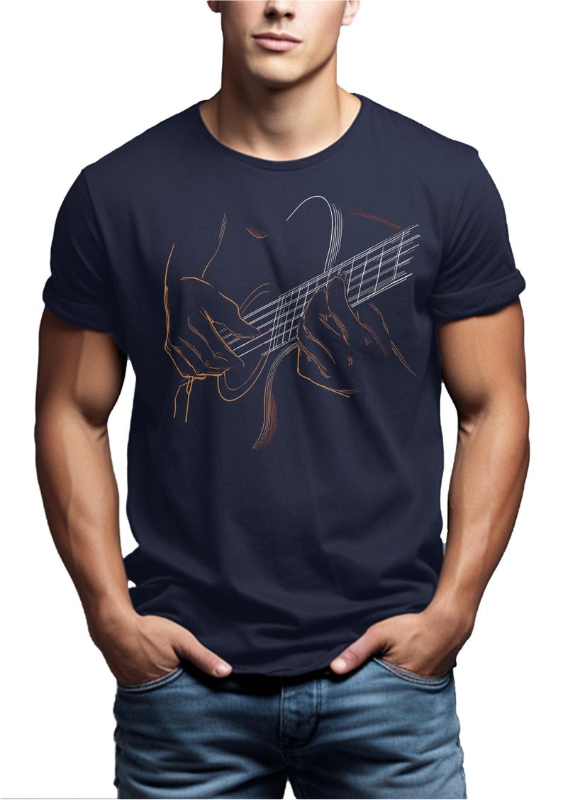 May include: Navy blue t-shirt featuring a line art illustration of a person playing a guitar. The design is in shades of orange and white, creating a striking contrast against the dark fabric. The shirt is a classic crew neck style.