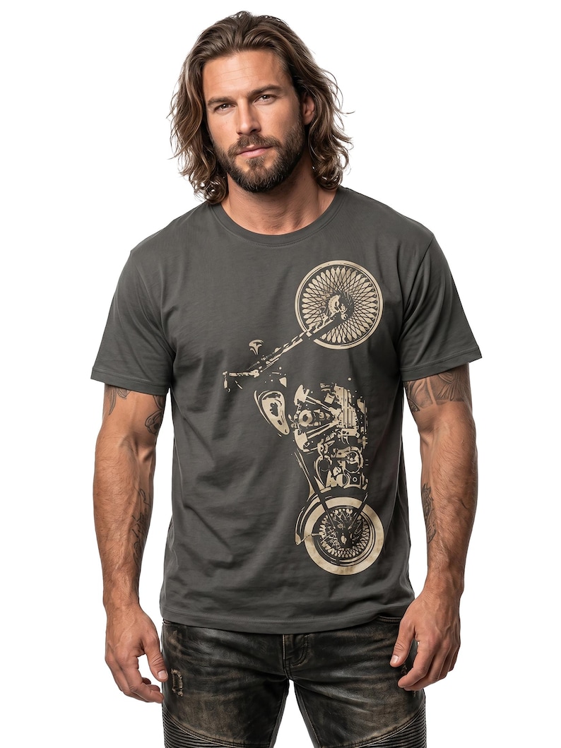 以下が含まれることがあります： 濃いグレーのTシャツ。ベージュのバイクのグラフィックが特徴です。デザインには、バイクの前輪と後輪、エンジン部品、フレームが含まれています。Tシャツは、クラシックなクルーネックです。