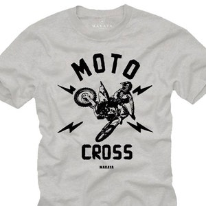 Peut inclure: T-shirt gris avec un motif noir d'un pilote de motocross sautant sur une rampe avec les mots "MOTO CROSS" et le nom de la marque "MAKAYA" imprimés sur le devant.