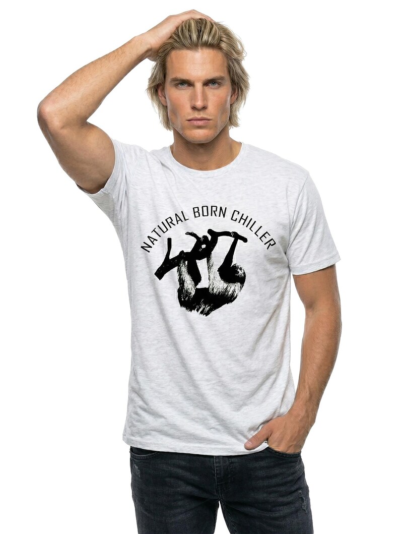 Pu&ograve; includere: T-shirt grigio chiaro con la scritta "NATURAL BORN CHILLER" e una grafica di bradipo nero. La maglietta &egrave; realizzata in materiale morbido, adatta per un abbigliamento casual.
