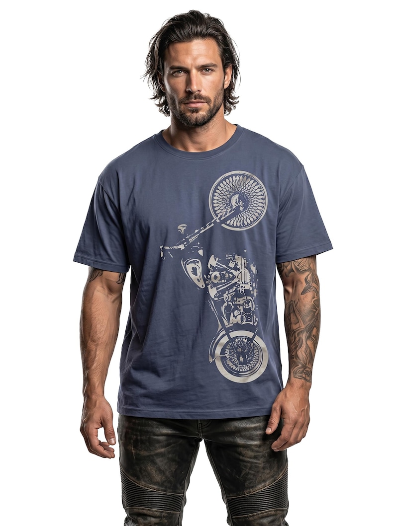 以下が含まれることがあります： ネイビーブルーのTシャツ。銀色のオートバイのグラフィックが特徴です。デザインは、前輪、エンジン、その他のオートバイの部品を示しています。Tシャツは無地で、クルーネックです。