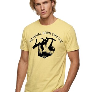 Pu&ograve; includere: T-shirt giallo chiaro con la scritta "NATURAL BORN CHILLER" sopra un disegno di bradipo nero. La maglietta a maniche corte &egrave; realizzata in tessuto morbido.
