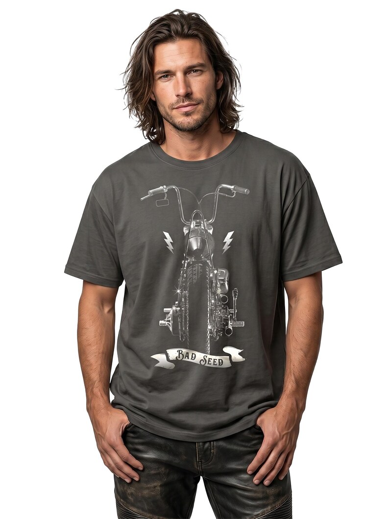 Puede incluir: Camiseta gris oscuro con un gr&aacute;fico detallado de motocicleta en blanco y negro. El dise&ntilde;o incluye rayos y una pancarta que dice "BAD SEED". La camiseta es de cuello redondo.