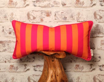 May include: A pink and orange striped lumbar pillow with a white tag that says "The Lazy Dog".