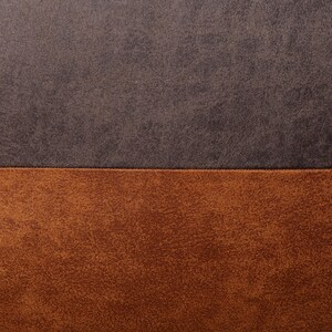 May include: Close-up of a brown and dark gray textured fabric. The fabric has a horizontal seam dividing the two colors.