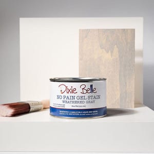 May include: A can of Dixie Belle No Pain Gel Stain in Weathered Gray, with a paintbrush and a wooden plank. The can is labeled with product information and a warning. The product is one pint (473 ml).