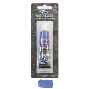 May include: A tube of French Lavender matte finish wax by Art Alchemy. The tube is blue and white, packaged in a clear plastic blister pack. The label reads "WAX MATTE FINISH" and "FRENCH LAVENDER". A swatch of the lavender wax is shown below the tube.