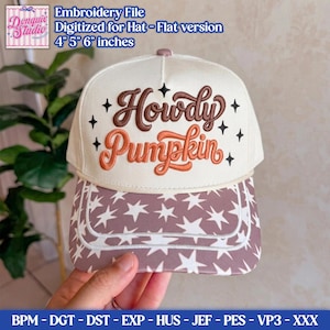 Puede incluir: Una gorra de béisbol color crema con el texto bordado Howdy Pumpkin en letra cursiva marrón y naranja, acentuada con iconos de estrellas negras. La visera muestra un patrón repetido de estrellas blancas sobre un fondo marrón.