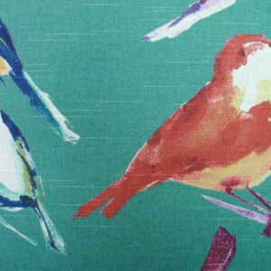 May include: A teal fabric with a watercolor pattern of birds. The birds are painted in shades of orange, yellow, blue, and white. The birds are perched on branches.
