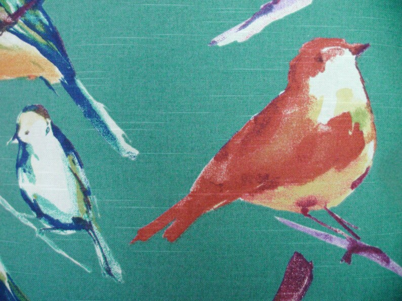 May include: A teal fabric with a watercolor pattern of birds. The birds are painted in shades of orange, yellow, blue, and white. The birds are perched on branches.
