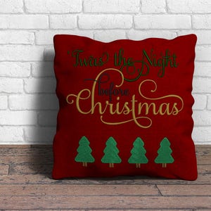 May include: Red throw pillow with the text "Twas' the Night Before Christmas" in gold script with green accents. Four green Christmas trees are embroidered below the text.