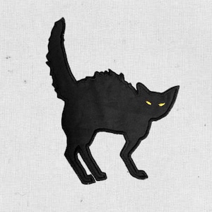 May include: Black felt applique of a cat with yellow eyes, arched back, and tail raised. The cat is facing right and appears to be in a defensive posture.