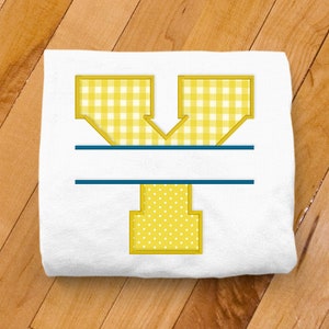 May include: A white t-shirt with a yellow letter Y. The letter is made of gingham and polka dot fabric. There is a blue line under the letter.