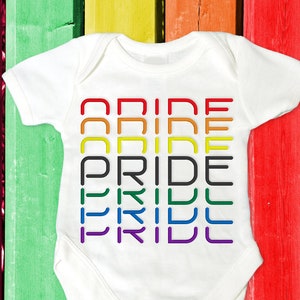 Könnte beinhalten: Ein weißer Baby-Strampler mit dem Wort "PRIDE", das in Regenbogenfarben wiederholt wird.