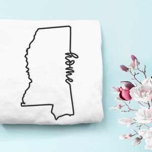 Può includere: Maglietta bianca con un contorno nero dello stato del Mississippi e la parola "home" scritta in corsivo.