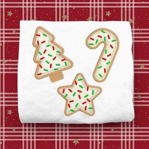 May include: Three Christmas-themed sugar cookies decorated with white icing and red and green sprinkles. The cookies are shaped like a Christmas tree, a candy cane, and a star.