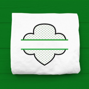 May include: White fabric with a green and black outline of a Girl Scout cookie shape with a green line across the middle.