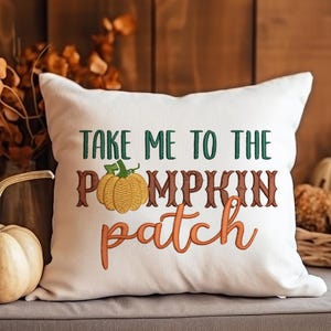May include: White throw pillow with embroidered text "Take me to the pumpkin patch" and a small orange pumpkin with a green stem.