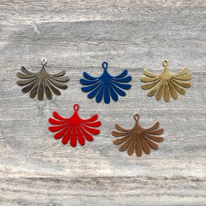 May include: Five metal fan-shaped ornaments in different colors. The ornaments are silver, blue, gold, red, and bronze.