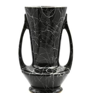 Könnte beinhalten: Schwarze und weiße Keramikvase mit zwei Henkeln. Die Vase hat ein marmoriertes Design mit weißen Adern auf schwarzem Hintergrund.