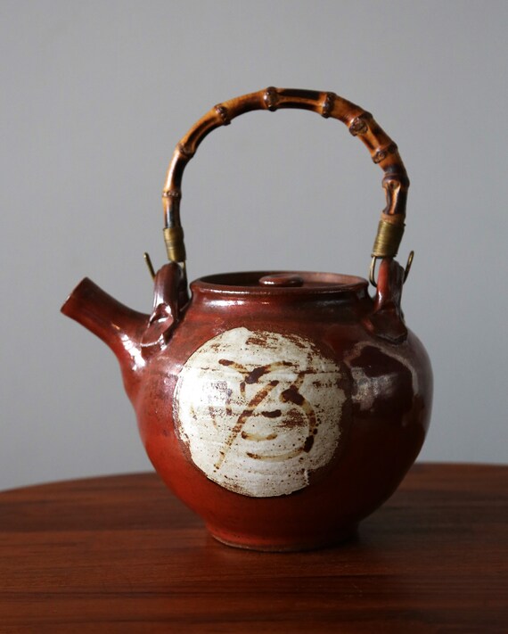 スタジオ陶器の竹製ハンドル付きストーンウェアティーポット。抽象的な