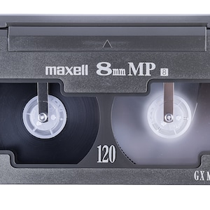 Może przedstawiać: Szara kaseta wideo Maxell 8mm MP 8 o pojemności 120 minut. Kaseta jest oznaczona jako "GX Metal".