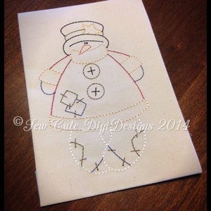 Op de afbeelding: Een witte sneeuwpop met een rood-witte hoed, twee zwarte knopen en een rode neus. De sneeuwpop houdt een klein wit vierkant in zijn rechterhand. De sneeuwpop is gestikt op een witte stof met de tekst "Sew Cute Digi Designs 2014" in de linkerbenedenhoek.