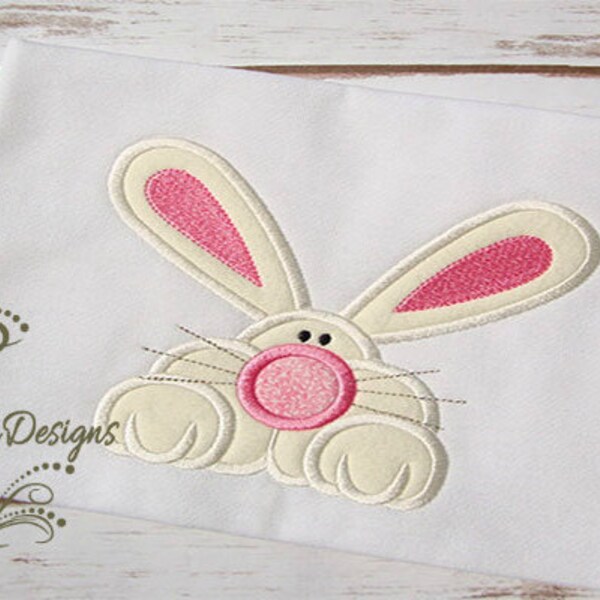 May include: Embroidered design of a white bunny rabbit with pink ears and a pink nose. The bunny is looking up with its paws in front of it.