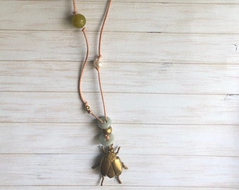 Long necklace with various types of semi-precious stones  and beetle shaped charm