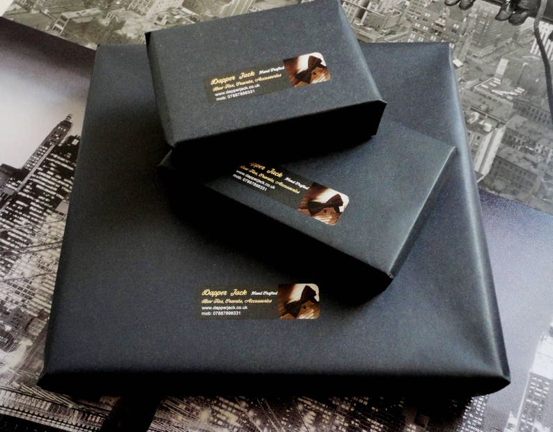 May include: Three black boxes with gold lettering and a logo of a bow tie. The text on the boxes reads "Dapper Jack Hand Crafted Bow Ties".