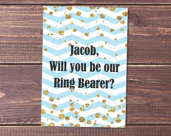 Op de afbeelding: Een blauwe en gouden puzzelkaart met de tekst "Jacob, wil je onze ringdrager zijn?"