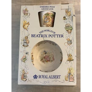 May include: A Royal Albert The World of Beatrix Potter children's ceramic bowl and mug set in original packaging. The white box features illustrations of various characters, including Jemima Puddle-Duck, and the text Ensemble Pour Les Enfants.